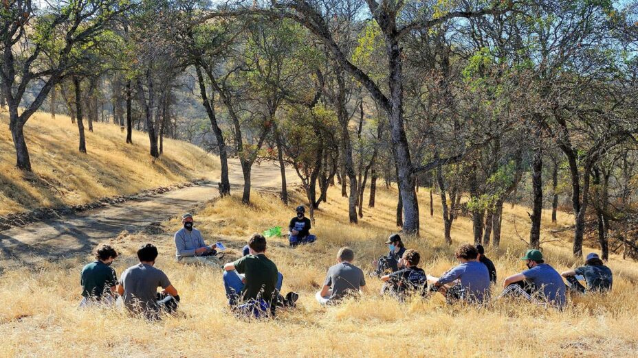 students sit in a circle in the grass amid blue oaks to begin nature solo at the Save Mount Diablo Big Bend property in the Marsh Creek watershed