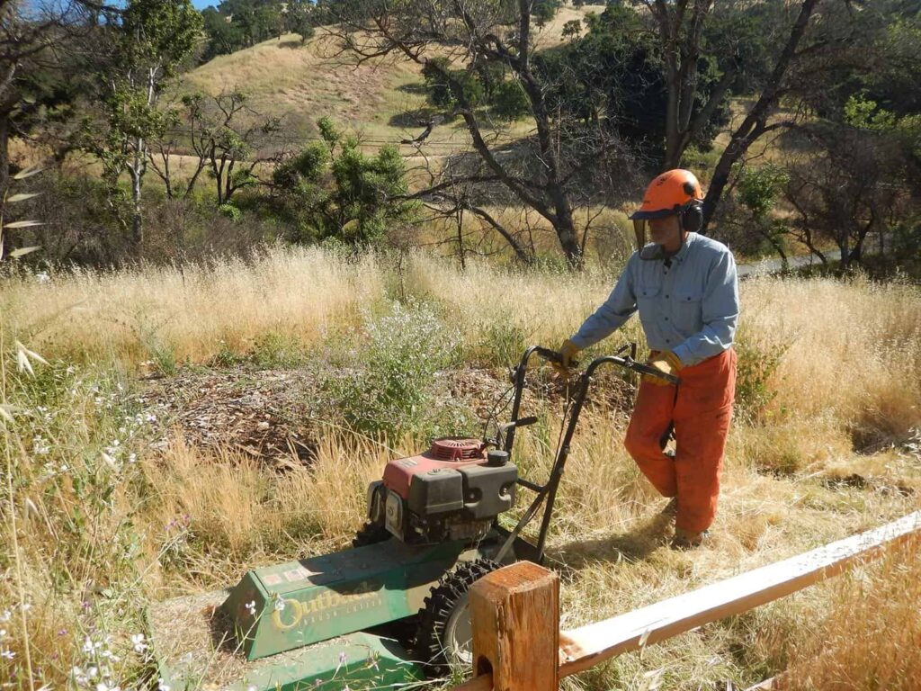 volunteer mowing the grass at Marsh Creek 4 to complete fire abatement