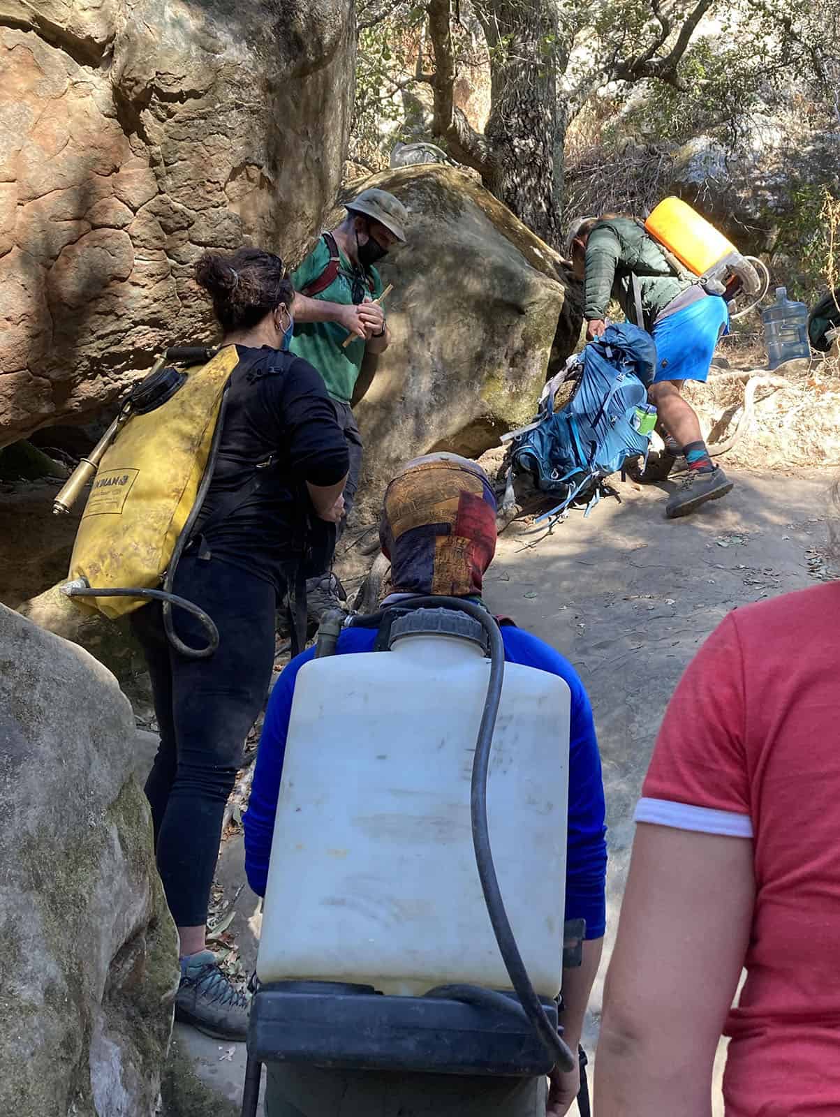 Volunteers hauling water up to clean Castle Rocks