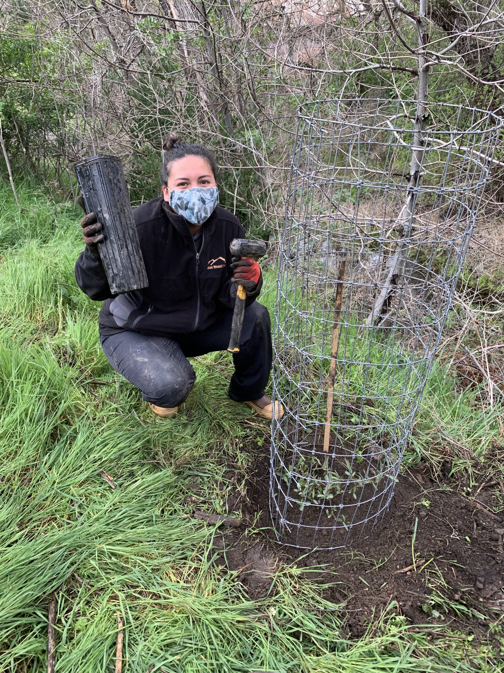 Roxana posing with willow planting tools (Haley Sutton)