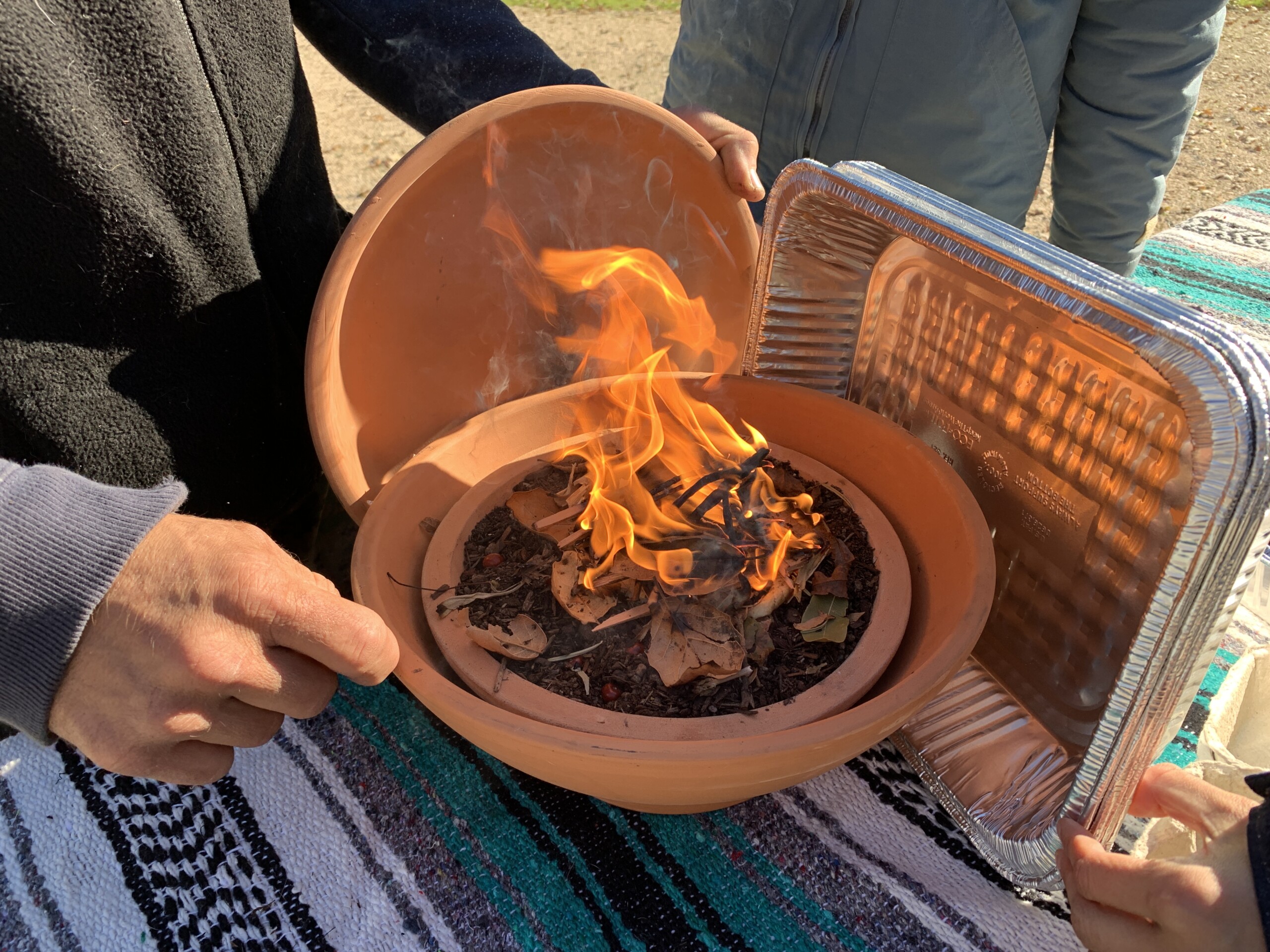 A small protected flame burning in a clay pot