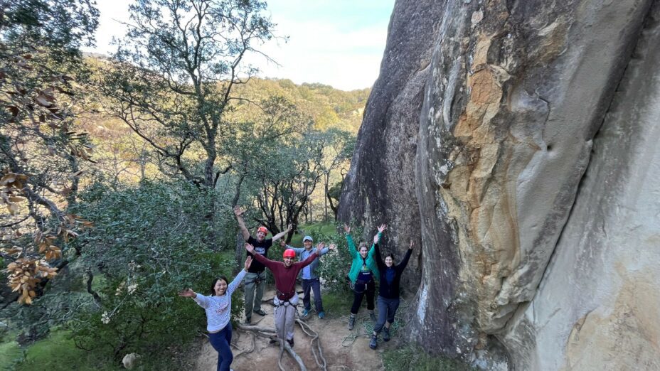 Climbers posing at the base of a rock formation