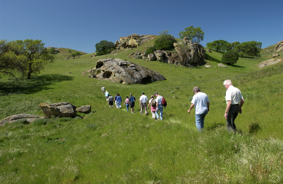 hikers in green hills at Vasco Caves