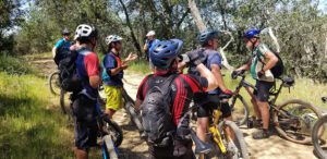 group of cyclists on the trail, quickly stopping to drink water