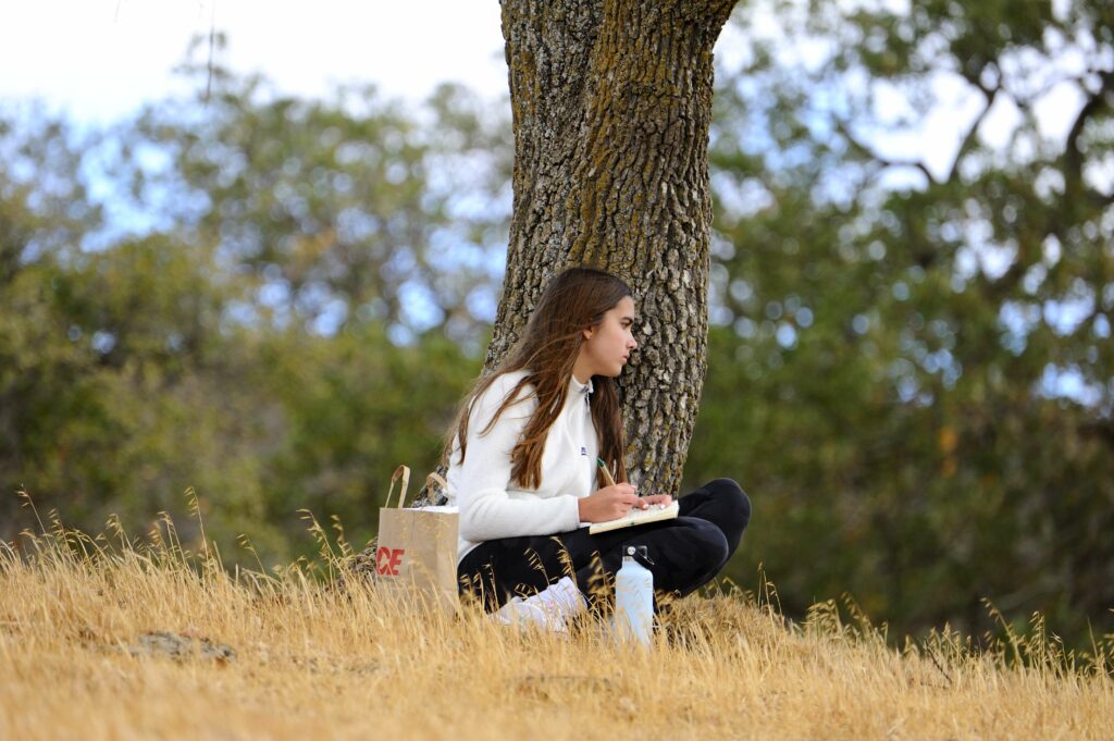 Girl sitting under tree on a contemplative solo