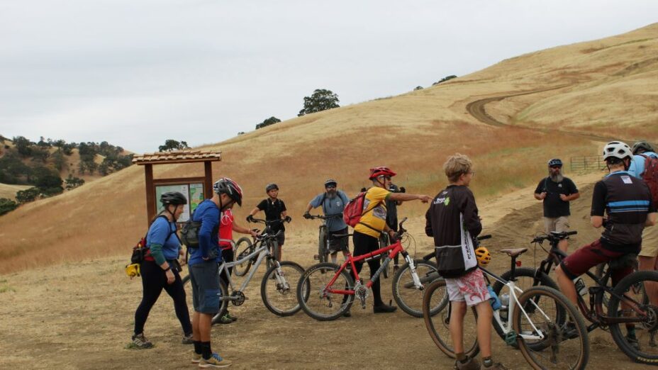 group of cyclists at the beginning of a windy dirt road