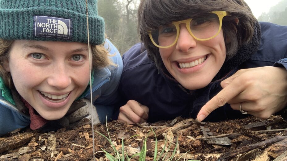 Two staff members pointing to our 2,000th planted plant