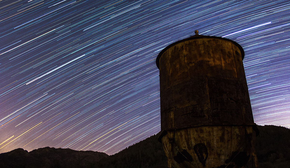Timelapse photography of the night sky in Mount Diablo State Park with a water tower in the foreground
