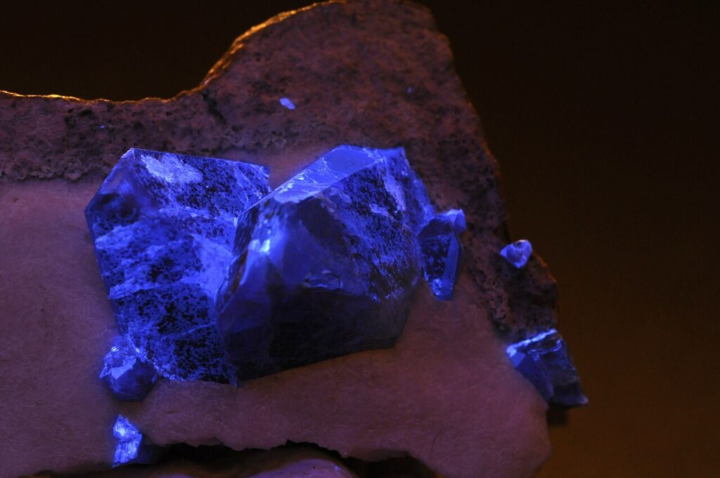 Benitoite crystals fluoresce under ultraviolet light.