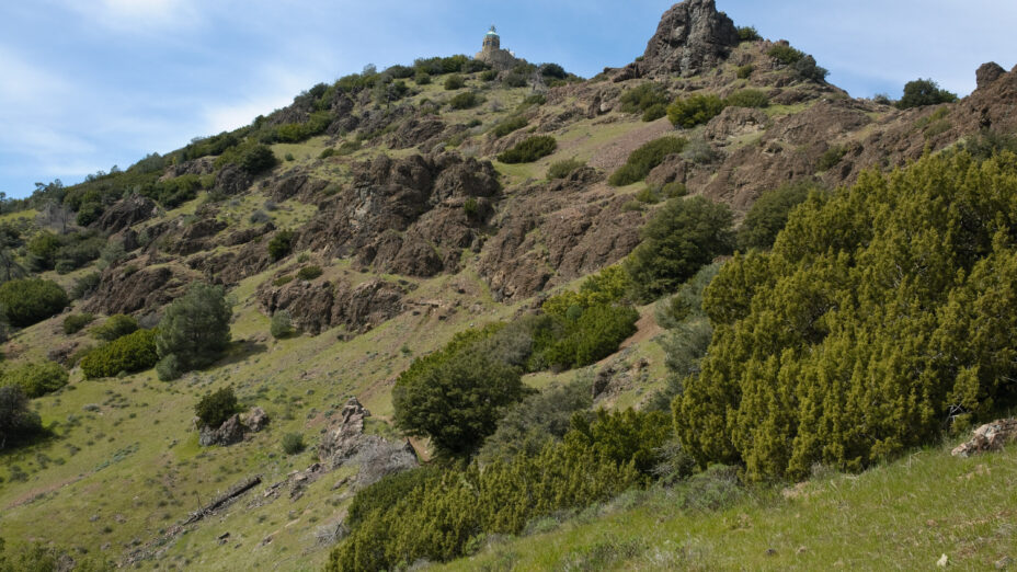 The Mount Diablo Summit Museum and Devils' Pulpit from the Devil's Elbow Trail cover in verdant green foliage. Photo by Scott Hein.